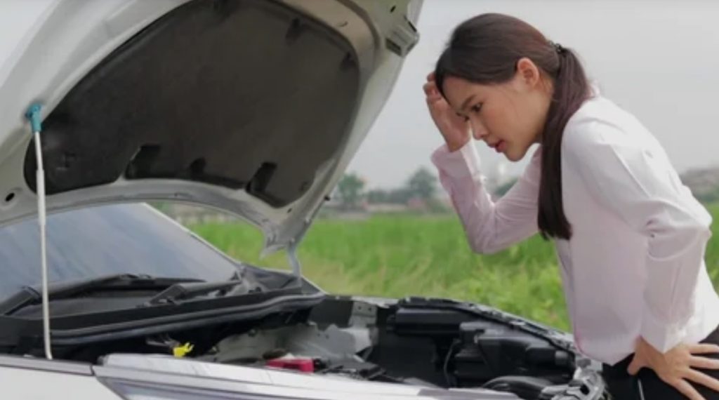 Girl thinking what is wrong with the car